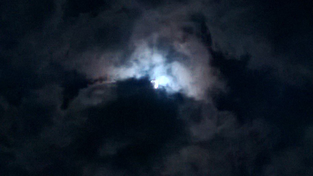 A pretty moon picture with light and clouds and stuff