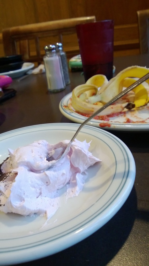 A spoon is somewhat supported at approximately a 45 degree angle in the mousse.