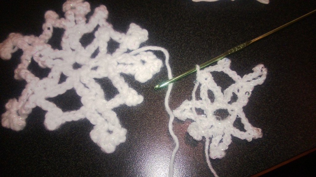a finished snowflake, and a crocheted one in progress.